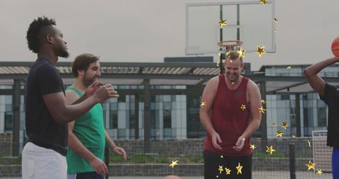 Five men playing streetball, laughing and passing on urban outdoor basketball court