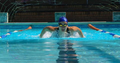 Female Athlete Powering Through Swimming Pool in Intense Competition