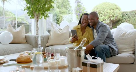 Joyful Couple Celebrating with Gifts and Refreshments at Home
