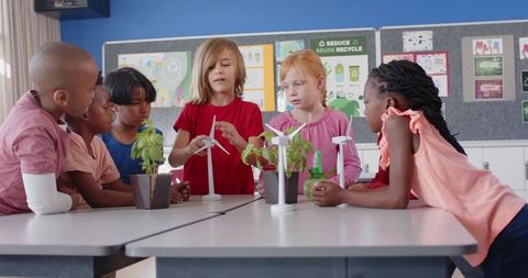 Diverse children exploring wind power and plant growth in classroom