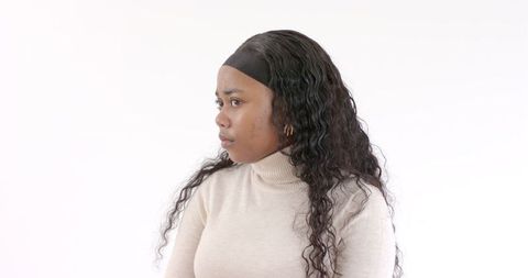 Thoughtful Woman in Turtleneck Against White Backdrop