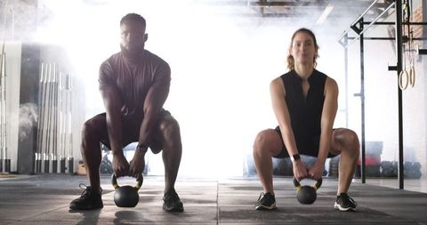 Diverse Athletes People Training with Kettlebells in Gym