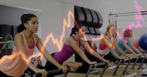 Women Stretching on Pilates Reformers Group Workout Session