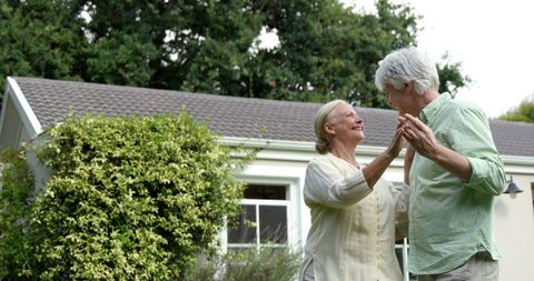 Elderly Couple Dancing Joyfully in a Peaceful Garden