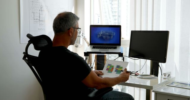 Architect analyzing building blueprints in a modern, well-lit office. This scene is useful for websites featuring architectural services, construction planning, or interior workplace environments. It can illustrate productivity, design processes, and professional office settings.