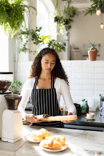 Young Biracial Female Barista Holding Bread in Cafe Kitchen - Download Free Stock Images Pikwizard.com