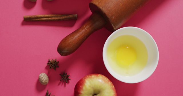 Image of baking ingredients, rolling pin and apples lying on pink background. baking, food preparing, taste and flavour concept.