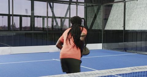 Man Playing Padel Tennis Focusing on Ball Return in Outdoor Court
