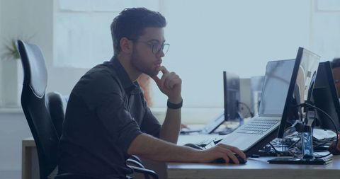 Focused Professional Working at Modern Office Station with Laptop