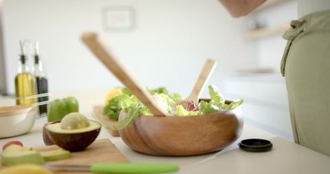 Caucasian Woman Preparing Healthy Salad in Bright Kitchen