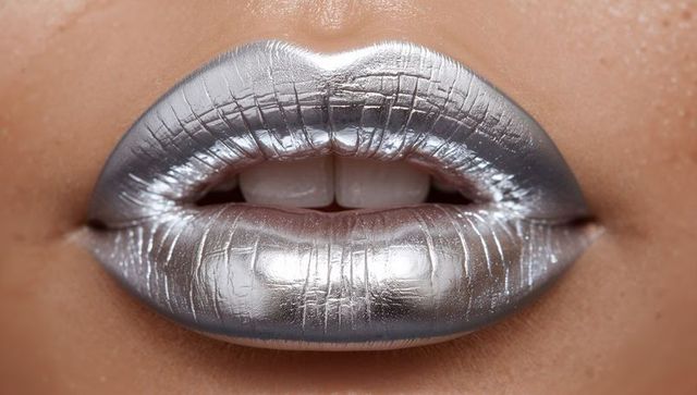 Futuristic silver metallic lips closeup highlighting high-gloss texture and lip line detail