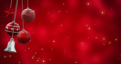 Perfect for Christmas cards, holiday greetings, festive banners or social media posts. The image features shiny baubles and a bell hanging on a red backdrop scattered with twinkling lights, capturing the essence of holiday spirit and celebration.