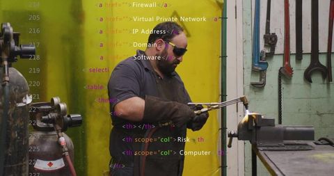 Skilled craftsman using blowtorch for metalwork in workshop