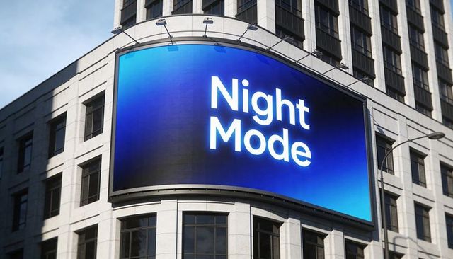 Curved led billboard displaying night mode on stone facade for urban digital advertising