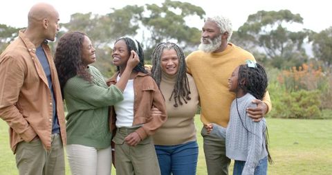 Multigenerational Black Family Embracing and Laughing on Park Lawn, Outdoor Lifestyle