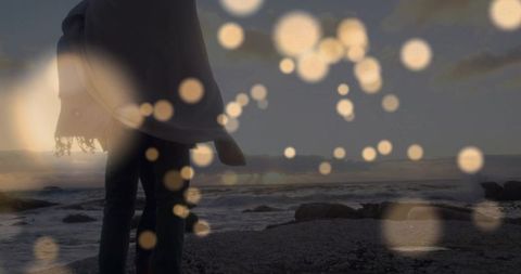 Couple Embracing on Rocky Shoreline with Bokeh at Dusk