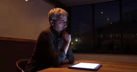 Man in Office Late at Night with Digital Tablet Ambient Light