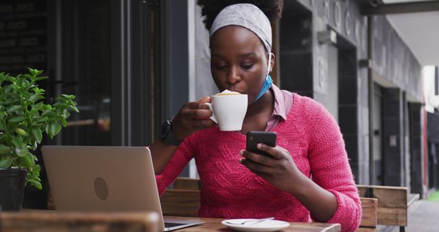 Woman in Pink Sweater Drinking Coffee and Using Smartphone at Outdoor Cafe - Download Free Stock Images Pikwizard.com