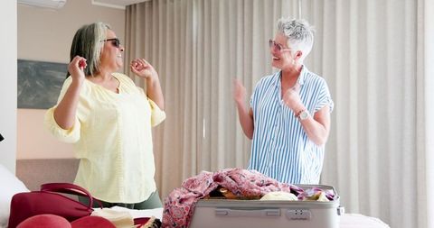 Joyful Senior Lesbian Couple Packing for Vacation