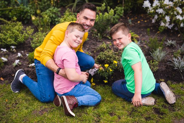 Portrait of caucasian father and two sons gardening together in the garden. fatherhood and love concept