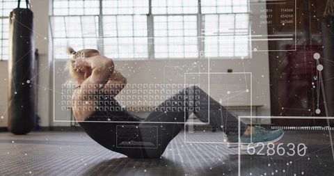 Woman doing abdominal crunches in industrial gym with futuristic hud overlays for fitness tracking