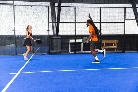 Diverse Friends Celebrating Win on Vibrant Blue Padel Court