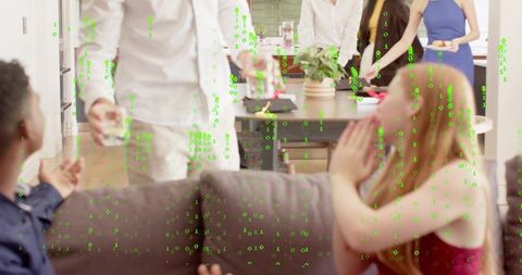 Casual home gathering man handing drink to woman on couch with green binary overlay tech