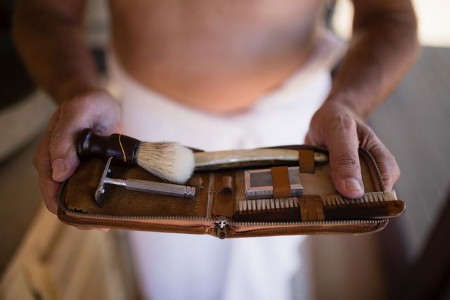 Mid-section of man holding shaving kit during safari vacation