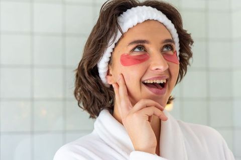 Applying under-eye gel patches during skincare routine for radiant glow