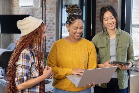 Diverse Female Team Collaborating in Urban Brick-Walled Office