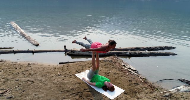 Couple Practicing Acroyoga on Beach by Tranquil Lake - Download Free Stock Images Pikwizard.com