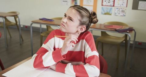 Thoughtful Schoolgirl Contemplating in Classroom