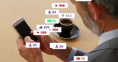 Senior businessman checking smartphone with social media notifications and coffee cup