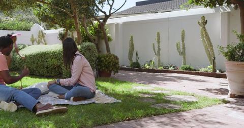 Family outdoor picnic within green suburban backyard