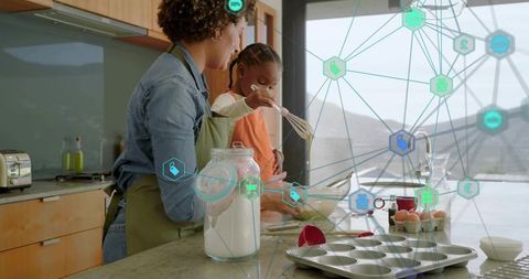 Mother guiding daughter mixing batter in modern kitchen with holographic baking network