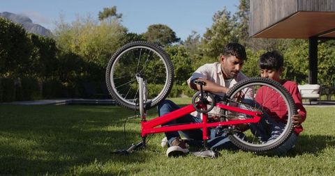 Father and Son Bonding while Repairing Bicycle on Lawn