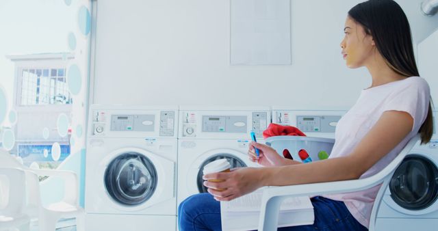 Young Woman Relaxing in Self-Service Laundromat While Waiting for Laundry - Download Free Stock Images Pikwizard.com