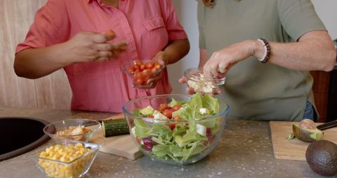 Diverse Women Preparing Fresh Salad in Modern Kitchen