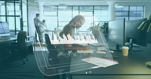 Businesswoman analyzing digital data overlay in modern open-plan office collaboration