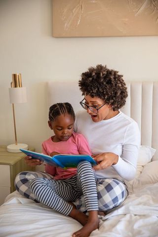 Mother Reading Bedtime Story with Daughter