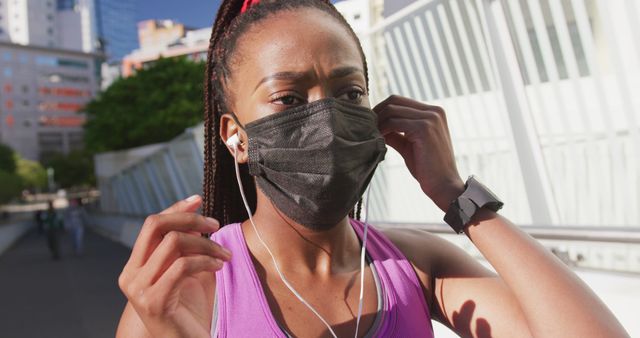 Fit Woman Jogging in Urban Area Wearing Face Mask and Listening to Music - Download Free Stock Images Pikwizard.com