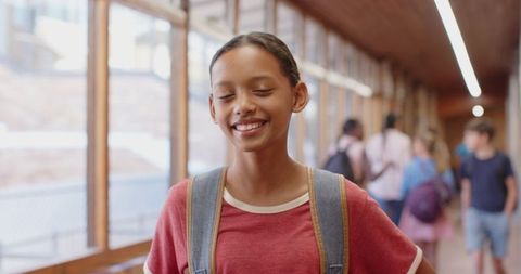 Smiling Schoolgirl with Backpack in Bright Hallway