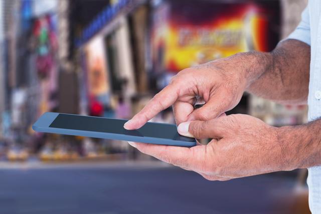 Hand holding and using a digital tablet with a defocused busy city background. Ideal for articles and advertisements focusing on technology, urban living, mobile devices, and modern lifestyles.