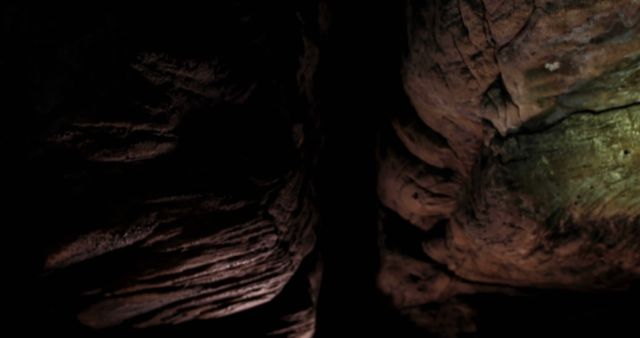 Rock formations in dark natural cave system, copy space. Geology, exploration, caving, nature and underground.