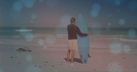 Mature Man Holding Surfboard on Tranquil Beach