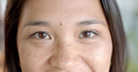 Portrait focus on freckle-faced asian businesswoman smiling brightly