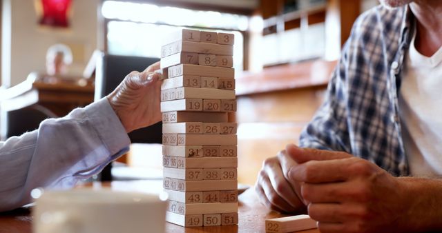 Two People Playing Wooden Block Numbers Game at Table - Download Free Stock Images Pikwizard.com