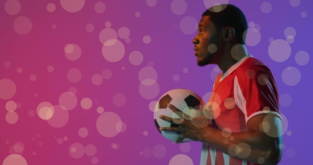 African American Football Player Holding Ball Against Colorful Background - Download Free Stock Images Pikwizard.com