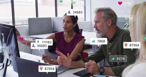 Colleagues collaborating on social media analytics using devices in modern office