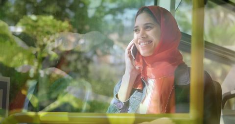 Smiling Woman in Hijab Enjoys Sunny Day Communicating on Phone